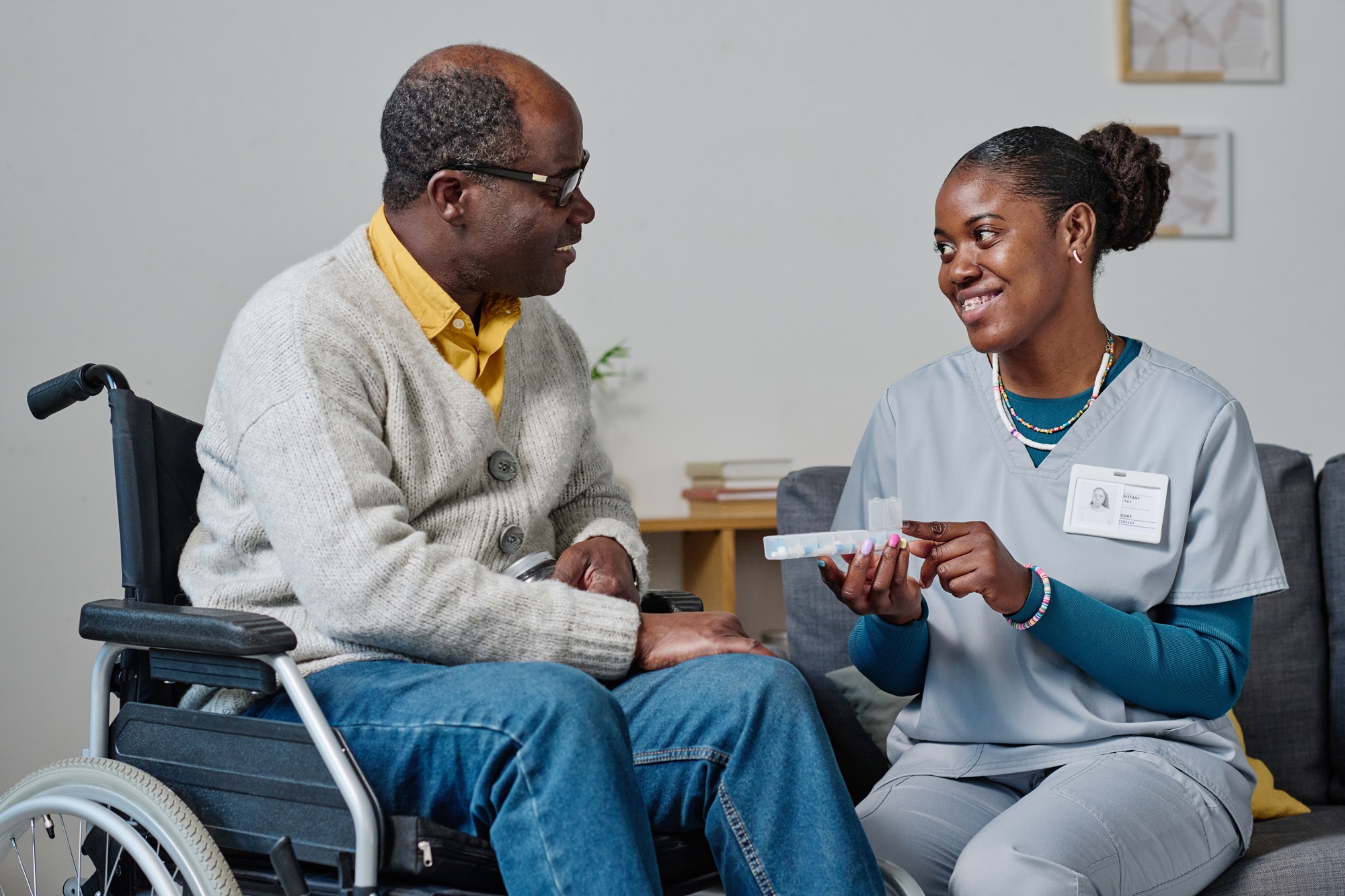 Caregiver Assisting Man With Medication